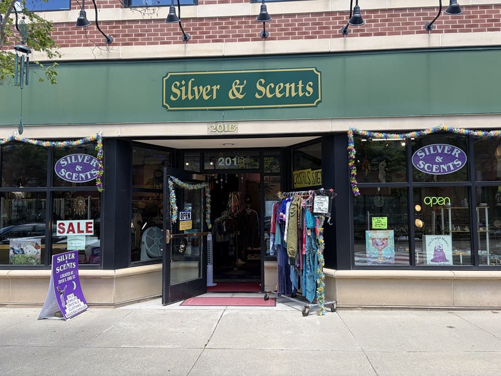 The front of Silver and Scents' store, located in Kent, Ohio. The store contains purple signs, clothing racks outside, and a variety of jewelry, gifts, and trinkets.