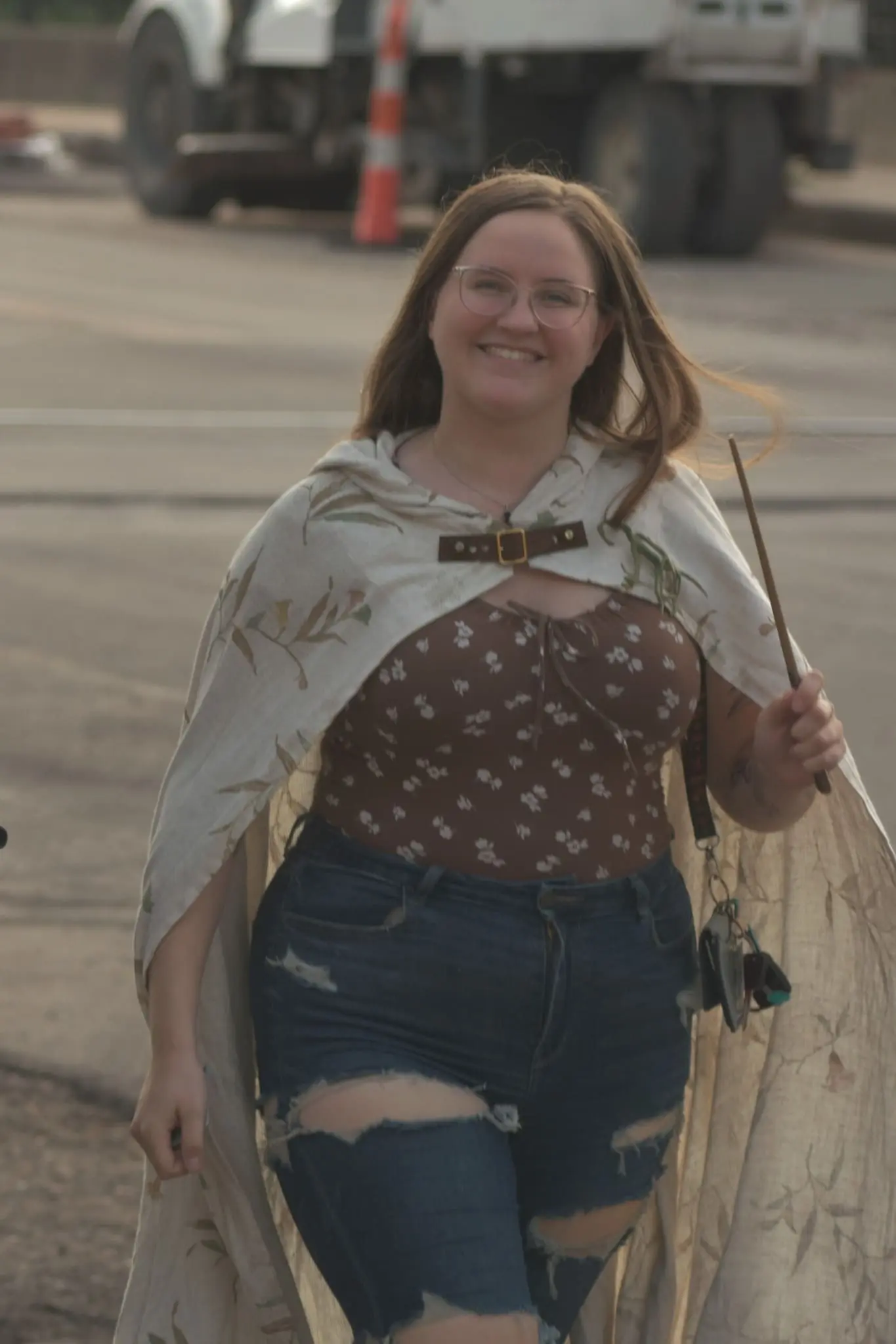 A wizard from Kent Ohio's Wizardly Worlds of Kent in Kent, Ohio, walks with a cape behind her and holds a wand